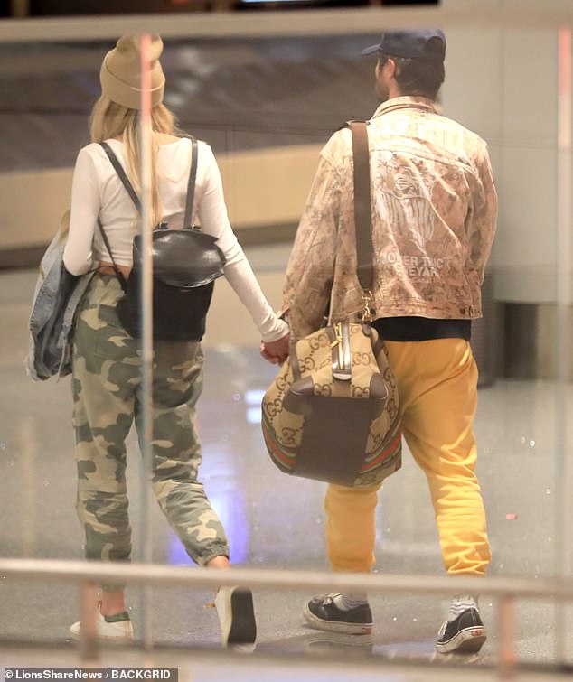 Confirming their romance: Her carry-on consisted of a Gucci duffel bag that she slung over her shoulder as she walked hand in hand with the blonde beauty.