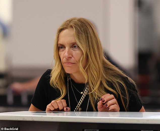 Toni leaned against the desk as she spoke to the staff member before her flight.