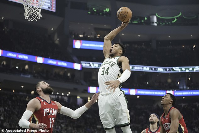 Giannis Antetokounmpo of the Bucks dunks on the ball Jonas Valanciunas of the New Orleans Pelicans