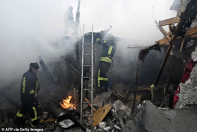 Ukrainian firefighters work on a burning house after Russian shelling in the city of Kherson on Sunday.
