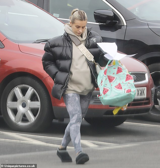 Stylish: Dani bundled up in a black puffer Prada jacket, which she layered over a beige hoodie and gray patterned leggings.