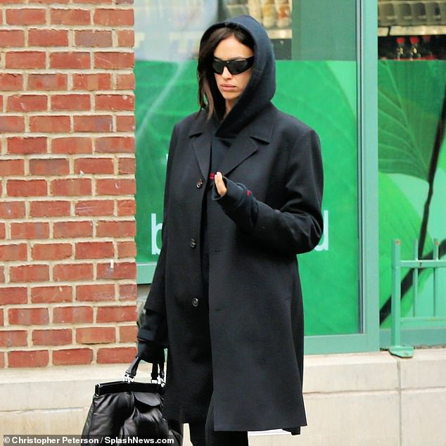 Warm: Irina kept herself warm in an oversized fleece coat that she paired with a hoodie and stylish pants