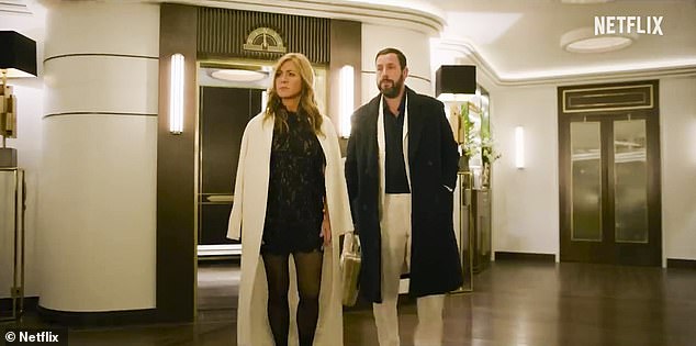 Chic in the city: Here Aniston is seen wearing a white coat over a black dress