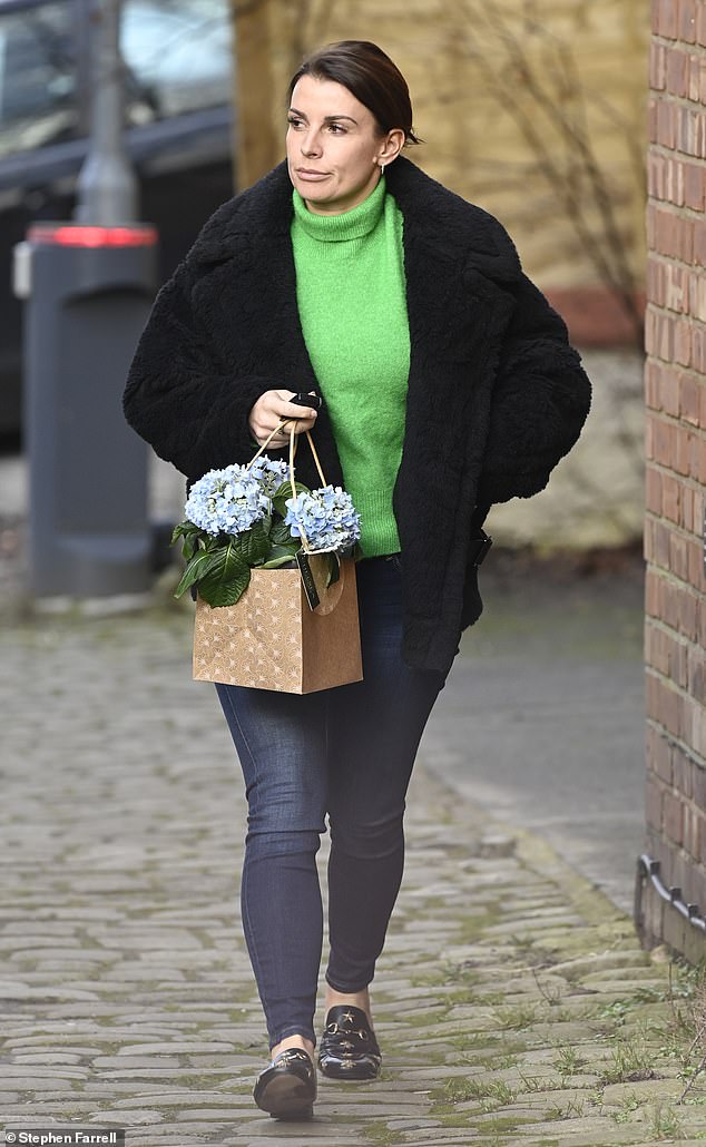 Out and about: The WAG, 36, rocked a pair of dark blue denim skinny jeans that she teamed with a bright green turtleneck jumper for the outing