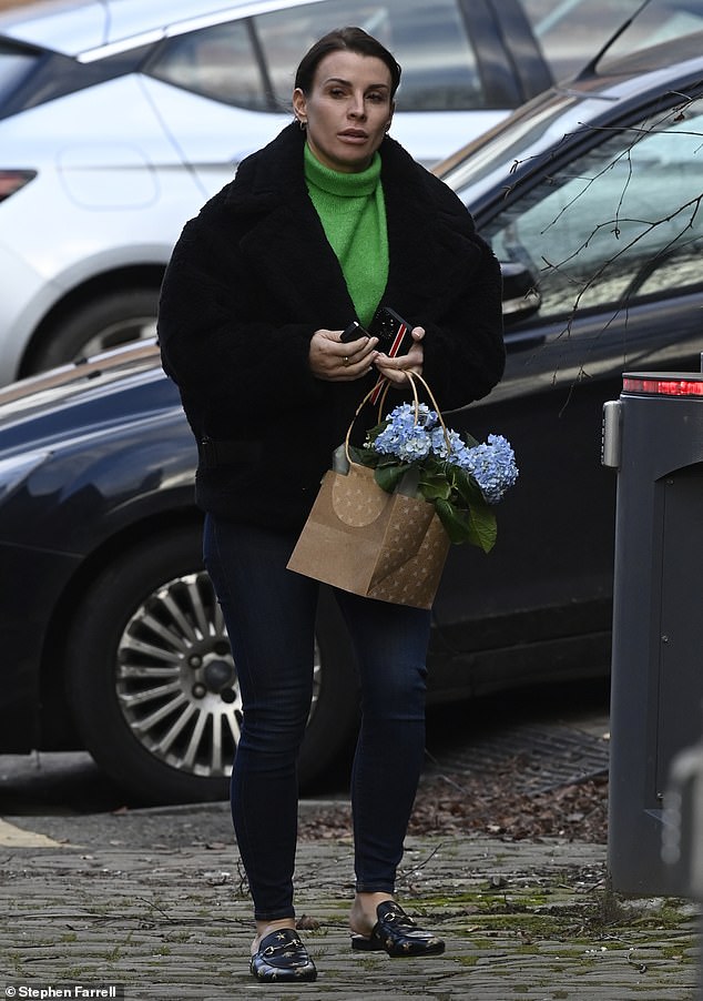 Stylish: She stayed warm in a cozy black coat and opted for a pair of sleek black Gucci backless loafers that she put gold stars and bees on