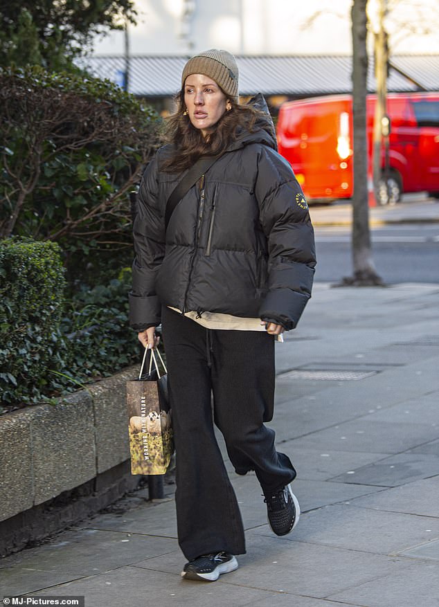 Understated: The beauty kept cozy in a pair of black and white sneakers while donning a crossbody bag over her torso