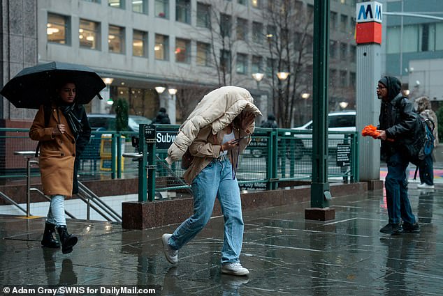 People walk through a mix of sleet and snowfall in downtown Brooklyn, New York, on January 25, 2023. New York City has gone 321 consecutive days without recordable levels of snowfall, according to the National Weather Service for USA