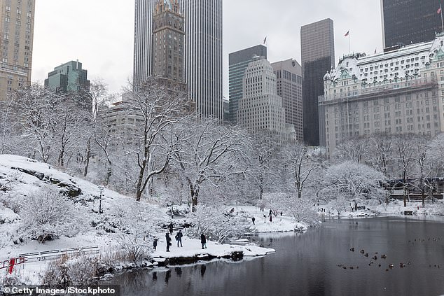 The pond in winter Central Park with the famous Plaza Hotel and the skyscrapers of Manhattan in the background during one of the snowiest days in New York City.  According to the Weather Channel, the last time New York City saw measurable snow was March 9, 2022.