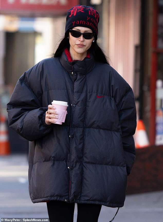 A different catwalk: Amelia walks the streets of Manhattan with a cup of hot coffee