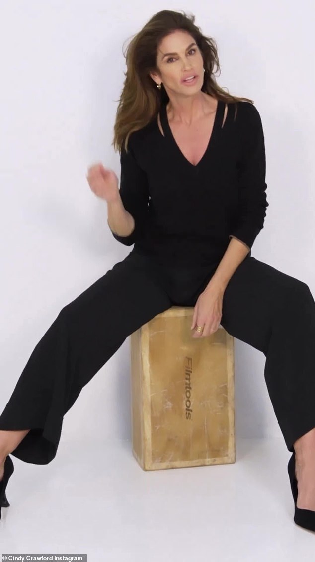Sexy: Cindy sat on a wooden box in a sexy pose as she leaned forward and then pushed her brunette hair out of her face.  She wore nice daytime makeup in the clip, complete with a natural pink lip.