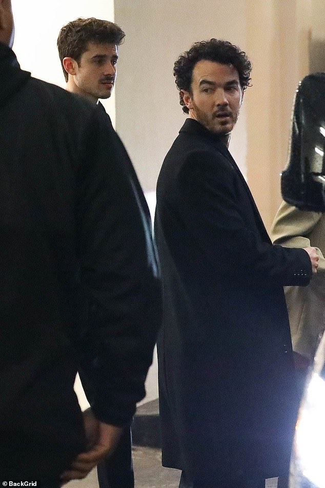 Handsome: Kevin Jonas cuts a stylish figure in a long black coat