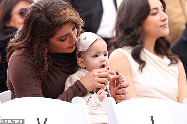 Adorable: For her world debut, the couple's daughter wore a beige tweed jacket and matching skirt, as well as a white floral headband