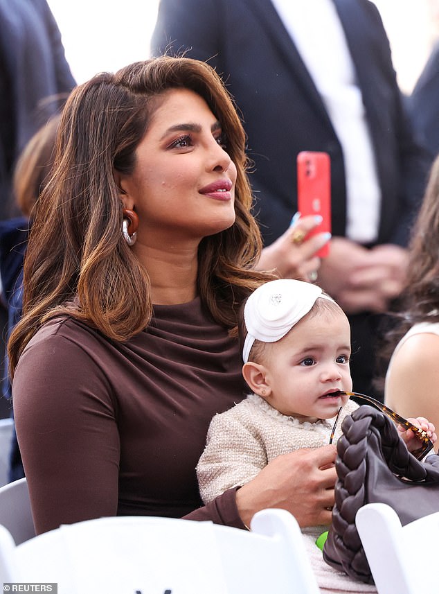 Doting mom: Meanwhile, her mom rocked a dark brown dress, gold hoop earrings, and hair styled in loose waves