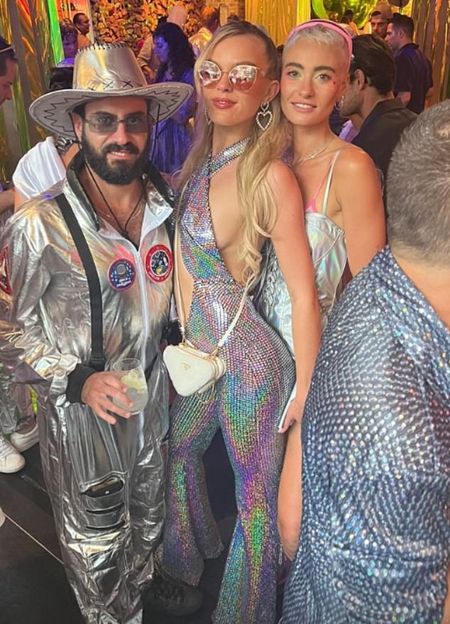Madeline showed off some sideboob in her Ava Meridian Nebula jumpsuit paired with a chic Prada bag