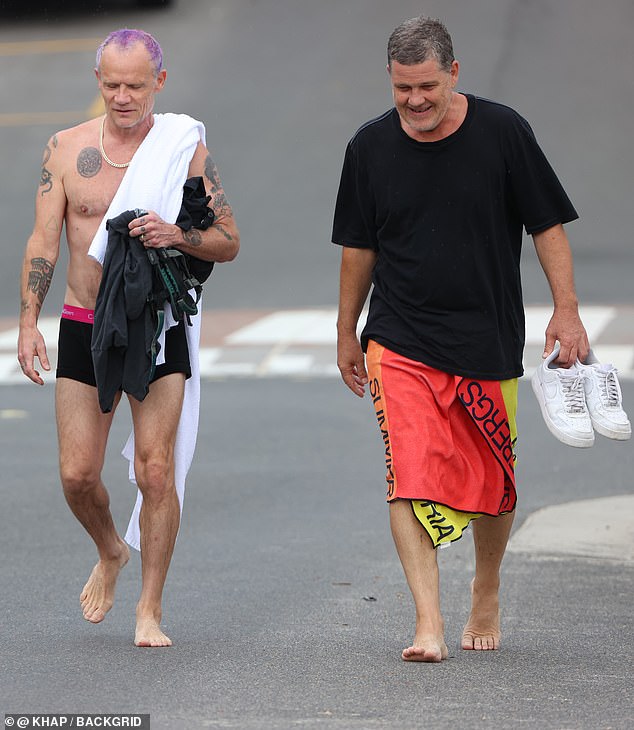 After a busy day at the beach, Flea tucked her clothes under her arm and tossed her towel over her shoulder as she walked back to the parking lot.