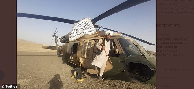 A Taliban fighter poses with a US-made Afghan Air Force Blackhawk helicopter at Kandahar airfield in August 2021, as weapons fell into the hands of the country's new rulers.