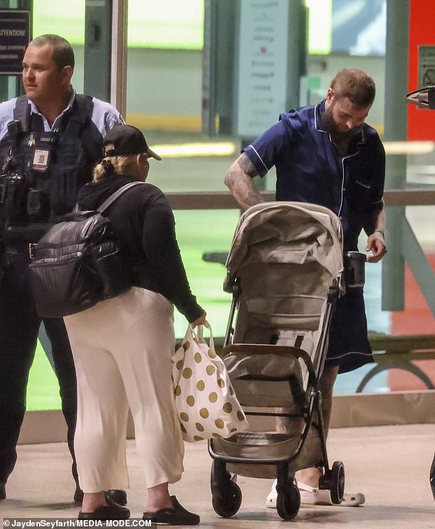Malone was seen pushing his daughter's stroller through the terminal as he made his way to a waiting car with his entourage.