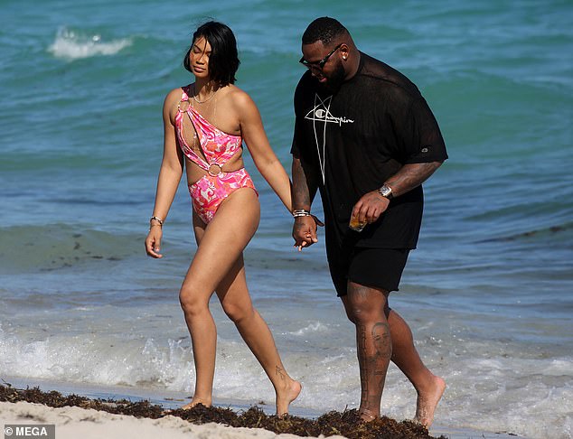 Miami Style: Iman shone in her asymmetrical swimsuit while Godchaux looked dapper in her black Campion shirt and matching swimsuit.