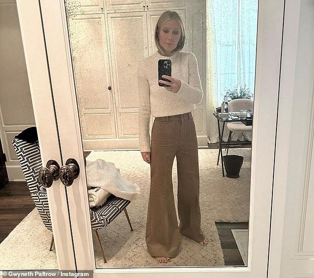 Winter theme: The Goop founder also shared a selfie while modeling a chic white sweater that was tucked into the waistband of sand-colored pants with flared cuffs.