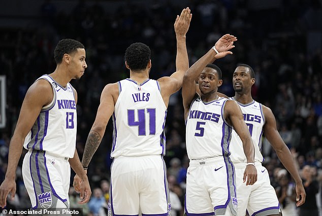 From left to right, Sacramento Kings Keegan Murray (13), Trey Lyles (41), De'Aaron Fox (5) and Harrison Barnes celebrate after the overtime win against the Minnesota Timberwolves