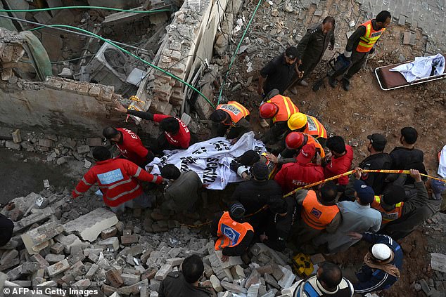 Rescue workers carry the remains of the blast victims from the debris of a damaged mosque after a blast inside the police headquarters in Peshawar on Monday