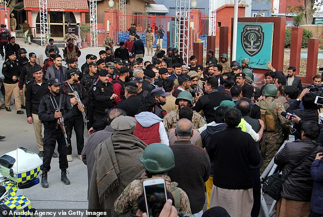 Injured people are being carried to ambulances at the site of the suicide bomb attack in Peshawar on Monday