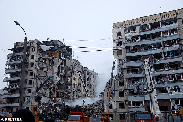 Emergency personnel work at the site in Dnipro, Ukraine, where an apartment block was badly damaged by a Russian missile attack.