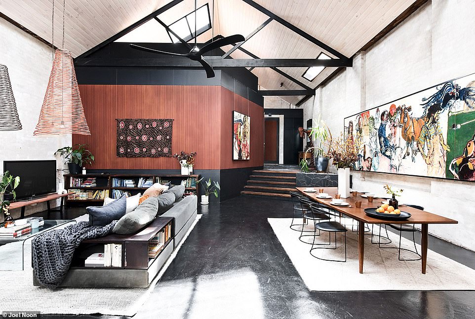 There is a spacious lounge and dining room that features light wood ceilings contrasting with exposed black beams, as well as polished concrete floors and plastered brick walls that recall the home's centuries-old roots.