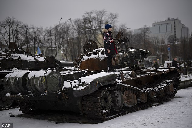 Ukraine has exceeded expectations with its fierce defense of Kyiv and subsequent counter-offensives, but West, the former First Sea Lord, said if it weren't for Western weapons supplies, Kyiv's armies would already be being pushed back.  Pictured: A boy stands on a destroyed Russian tank pictured in central Kyiv, Ukraine, on January 31.