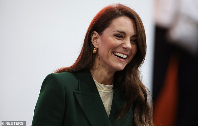 The Princess of Wales was all smiles as she spoke to staff at Kirkgate Market.  She paired her cream colored dress with an emerald green Alexander McQueen coat and gold earrings.