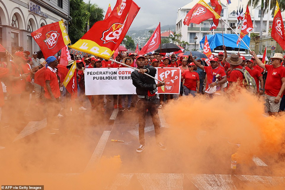 Protesters demonstrate with banners and flags on a second day of nationwide strikes and protests over the government's proposed pension reform, in Saint-Denis de la Reunion on the French Indian island of La Reunion on Tuesday