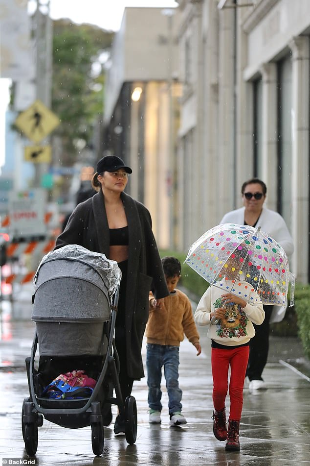 Happy family: her little brother looked adorable in a furry orange jacket, jeans and white sneakers