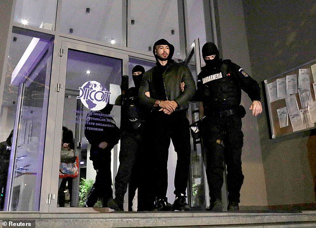 Andrew Tate and Tristan Tate (not pictured) are escorted by police officers out of the headquarters of the Organized Crime and Terrorism Investigation Directorate in Bucharest.