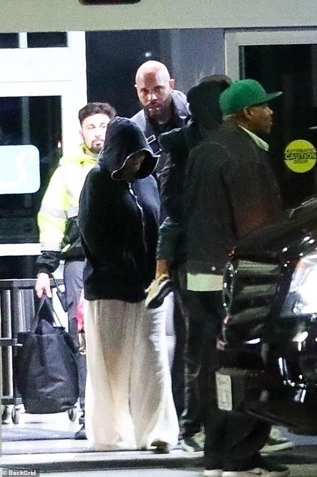 Going undercover: Beyoncé Knowles-Carter wore a black hoodie and white sheer palazzo pants when she touched down at LAX airport in Los Angeles on Monday night with her family and a large entourage.