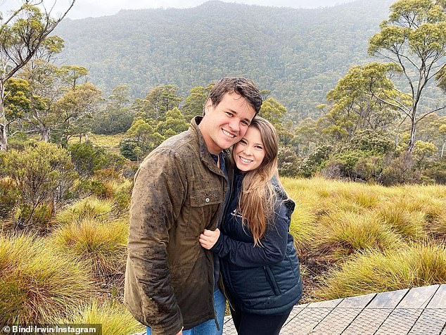 Bindi Irwin has revealed how a rhino named 'DJ' has become 'part of the family'.  Pictured is her with her husband Chandler (left)