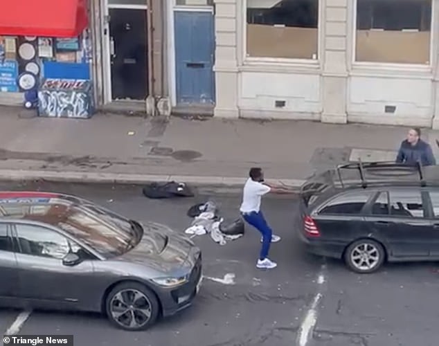 This is the bizarre moment a man ripped a windshield wiper off a car in a road rage fight over dirty laundry