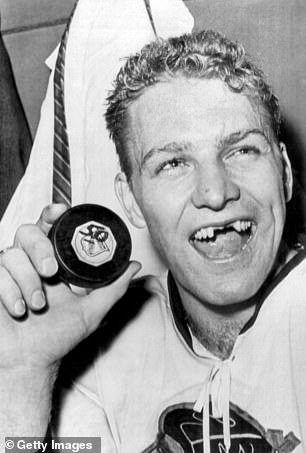 Hull holds the puck with which he scored his 50th goal of the season, becoming only the third man in National Hockey League history to score so many in a single season.