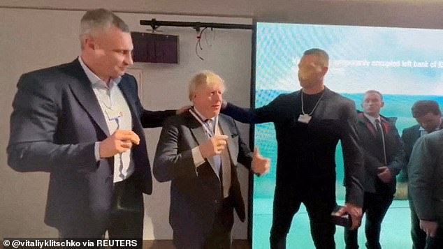 Boris Johnson received the award from boxing greats Wladimir (right) and Vitali (left) Klitschko - the latter of whom is now mayor of the city - at the Swiss resort last night