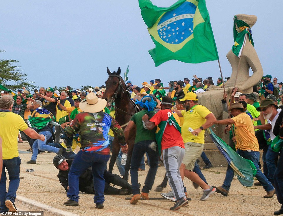 A Military Police officer falls from his horse during clashes with supporters of Brazilian former President Jair Bolsonaro