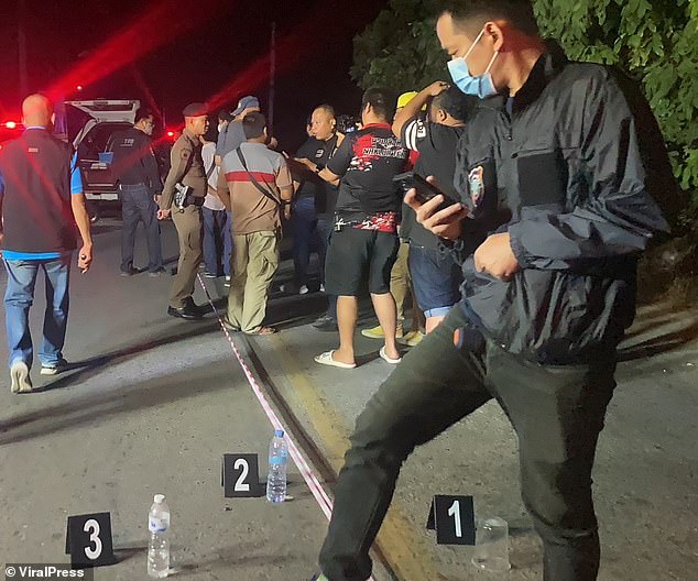 A British pensioner has been killed when he was shot four times in the back while riding his scooter in Thailand.  Pictured: Police officers and paramedics are seen at a crime scene after the retired engineer was shot four times in the back while riding his moped down a dark road in Pattaya on Thursday night.  He was found around 10:30 p.m.