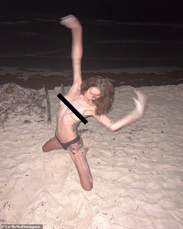 Australian supermodel Catherine 'Cat' McNeil, 33, ringed in the new year by sharing this topless photo on the beach on Sunday.  Daily Mail Australia has censored the image