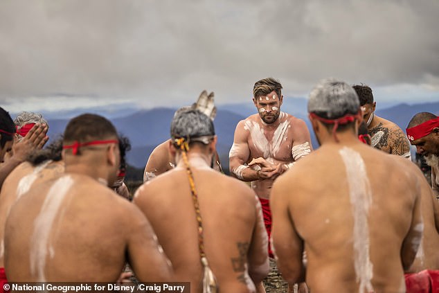 Chris Hemsworth painted white ocher and dressed in a red lap is seen taking part in a cultural ceremony with Aboriginal dancers at Wright's Lookout in northern New South Wales.