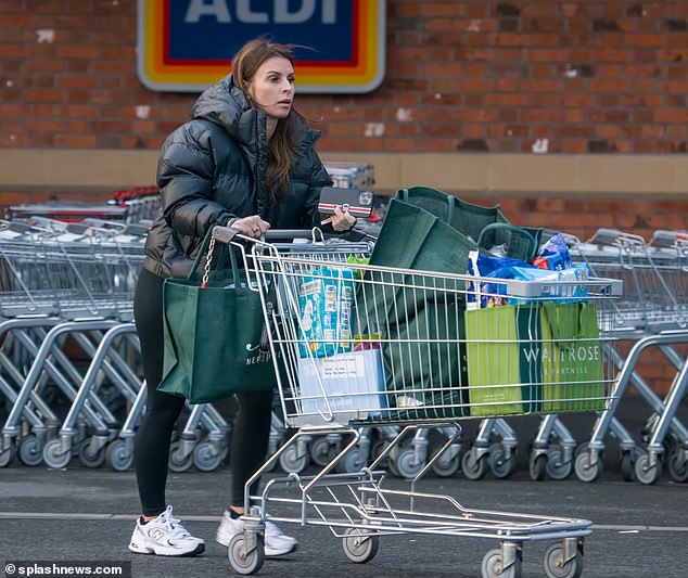 Deals for days: Coleen Rooney dressed warm for a shopping trip to Aldi on Friday as she hunted for some bargain buys