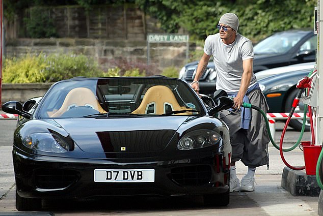 Ex-footballer David Beckham pictured filling up the tank of his Ferrari 360 Spider at his local petrol station in Alderley Edge, Cheshire, in 2002