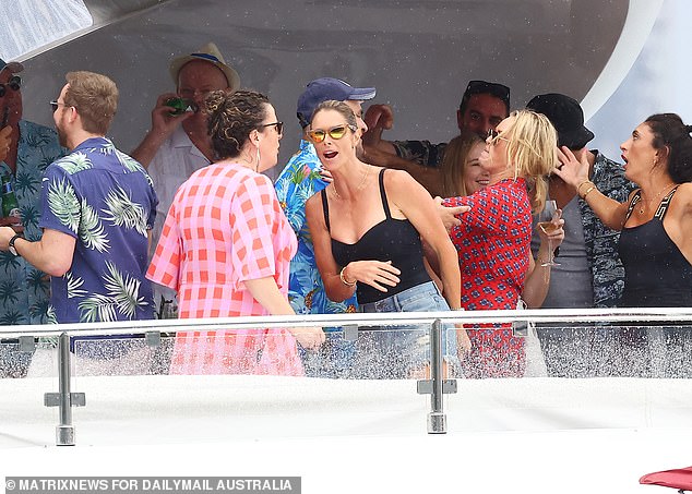 David and Candice Warner partied on a luxury yacht with their friends in Sydney before the cricketer stripped to his shorts for a refreshing shower.