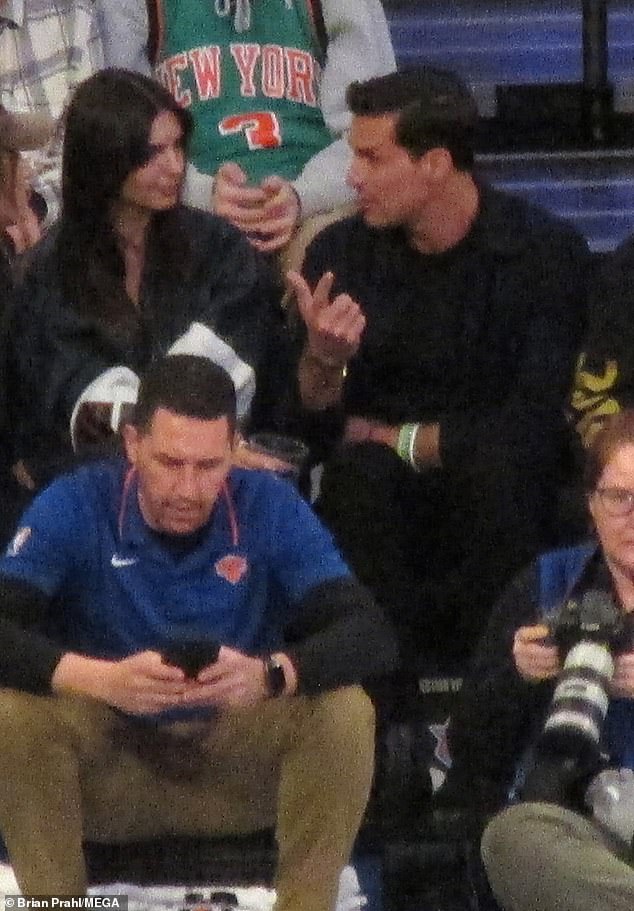 Who is he?  Emily Ratajkowski enjoyed a friendly chat with a mystery man at a Knicks game at Madison Square Garden on Wednesday.