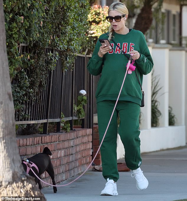 There it is: Heather Rae El Moussa, 35, showed off her growing baby bump while taking her dog for a walk in Newport Beach, Calif., on Thursday afternoon.