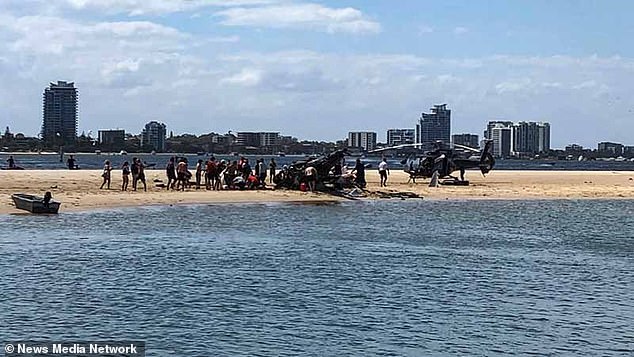 Three people are feared dead after two helicopters collided in mid-air near Sea World at the Gold Coast theme park as tourists looked on in horror.