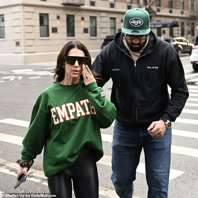 Hilaria wore a green sweatshirt with 'EMPATHY' - valued at $108 - emblazoned on the front, while looking pale and donned large dark glasses to cover her face as she was escorted to her car.