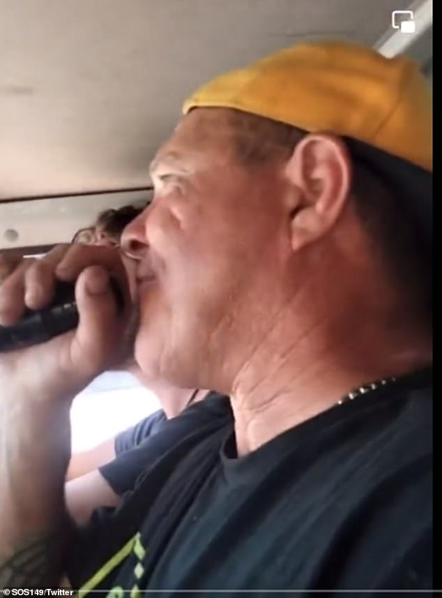 In a 'kitchen' video, a man with a loud megaphone drives around with friends in a car singing a slightly slurred invitation for all Australians to gather in Canberra on Australia Day.